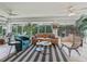 Bright living room with plush seating, stylish rug, and views of the lush outdoor greenery at 591 Allenwood Loop, The Villages, FL 32162