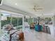 Bright living room with plush seating, stylish rug, and views of the lush outdoor greenery at 591 Allenwood Loop, The Villages, FL 32162