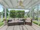 Charming outdoor seating area with a pergola and comfortable furniture surrounded by lush greenery at 591 Allenwood Loop, The Villages, FL 32162