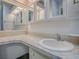 Bathroom vanity featuring mirrored cabinets and an extended countertop at 601 Jason Dr, The Villages, FL 32159