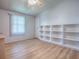 Minimalist bedroom with neutral walls, a built-in bookshelf, and lots of sunlight at 601 Jason Dr, The Villages, FL 32159