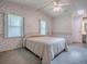 Bedroom with carpet, floral wallpaper, ceiling fan, windows and view to bathroom at 601 Jason Dr, The Villages, FL 32159