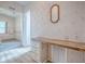 Bedroom with floral wallpaper, light flooring, built-in desk and cabinets, and a mirror at 601 Jason Dr, The Villages, FL 32159