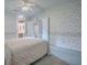 Bedroom featuring floral wallpaper, carpet, ceiling fan, and views to closet and bathroom at 601 Jason Dr, The Villages, FL 32159