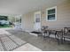 Covered carport showing a seating area and a white front door at 601 Jason Dr, The Villages, FL 32159