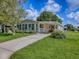 Charming home with sunroom, carport, and landscaped yard on a sunny day at 601 Jason Dr, The Villages, FL 32159