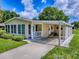 Inviting home with a cozy porch, carport, and sunroom perfect for relaxation at 601 Jason Dr, The Villages, FL 32159