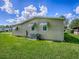 Exterior view of home featuring a well-maintained lawn, air conditioning unit, and window awnings at 601 Jason Dr, The Villages, FL 32159