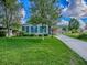 Well-maintained home featuring a spacious front yard, covered carport, and lush landscaping under a bright, partly cloudy sky at 601 Jason Dr, The Villages, FL 32159