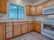 Bright kitchen featuring wooden cabinets, a sink under a window, and white appliances at 601 Jason Dr, The Villages, FL 32159