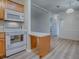 Kitchen featuring wood cabinets and white appliances in an open layout at 601 Jason Dr, The Villages, FL 32159