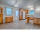Bright kitchen with wood-look floors, wood cabinets, white appliances, and a window at 601 Jason Dr, The Villages, FL 32159