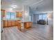 Open-concept kitchen featuring wood cabinets and a breakfast bar adjoining a living room at 601 Jason Dr, The Villages, FL 32159
