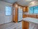 Cozy kitchen featuring wooden cabinets, a refrigerator, and a view of the door and sink at 601 Jason Dr, The Villages, FL 32159