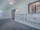 Well-lit living room with built-in shelving and large windows at 601 Jason Dr, The Villages, FL 32159