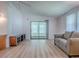 Open concept living space featuring light walls, wood-look flooring and sliding doors at 601 Jason Dr, The Villages, FL 32159