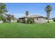 The backyard of the home features a well-manicured lawn and beautiful, mature landscaping at 6640 Sw 85Th Pl, Ocala, FL 34476