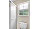 Bathroom showcasing a glass enclosed shower and a toilet with a window view at 6640 Sw 85Th Pl, Ocala, FL 34476