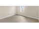 This bedroom has a wood floor, a window letting in natural light, and light-colored walls at 6640 Sw 85Th Pl, Ocala, FL 34476