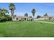 Attractive single-story home featuring large front lawn, tidy landscaping, and tall palm trees at 6640 Sw 85Th Pl, Ocala, FL 34476