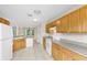 Open kitchen with light wood cabinets, gray countertops, white appliances and tile flooring at 6640 Sw 85Th Pl, Ocala, FL 34476