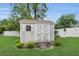 This backyard shed, surrounded by lush lawn and landscaping, offers additional storage at 6640 Sw 85Th Pl, Ocala, FL 34476