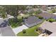 Aerial view of a well-maintained home with a gray driveway, complemented by green lawns and mature trees in a tranquil neighborhood at 670 Fayette Ct, The Villages, FL 32162