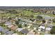Wide aerial view of a sprawling residential community, complete with manicured lawns, serene ponds, and a picturesque golf course at 670 Fayette Ct, The Villages, FL 32162