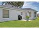 Backyard with a well-maintained lawn, white exterior of the home, and a gas grill at 670 Fayette Ct, The Villages, FL 32162