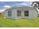 Well maintained back lawn and white home exterior featuring four large windows at 670 Fayette Ct, The Villages, FL 32162