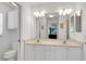 Elegant bathroom featuring double sinks, stylish lighting, and a separate toilet area at 670 Fayette Ct, The Villages, FL 32162