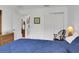 Bright bedroom featuring a blue bedspread, wicker furniture, and an open doorway to another room at 670 Fayette Ct, The Villages, FL 32162