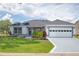 Charming single-story home featuring a well-manicured lawn and an attached two-car garage at 670 Fayette Ct, The Villages, FL 32162