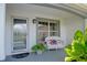 Inviting front porch featuring a decorative bench and American flags, creating a welcoming entrance at 670 Fayette Ct, The Villages, FL 32162