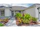 Well-maintained front yard with mulch beds and vibrant plants adding curb appeal to the home at 670 Fayette Ct, The Villages, FL 32162