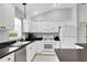 Bright kitchen features white cabinetry, appliances, and dark countertops at 670 Fayette Ct, The Villages, FL 32162