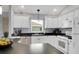 Beautiful kitchen with white cabinets, stainless steel dishwasher, and black counters at 670 Fayette Ct, The Villages, FL 32162