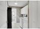 Functional laundry room with washer, dryer, cabinet storage, and decorative wallpaper at 670 Fayette Ct, The Villages, FL 32162