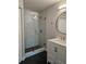 Modern bathroom featuring a glass shower and vanity with a round mirror at 711 Sugar Bay Way # 115, Lake Mary, FL 32746
