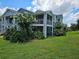 Apartment building featuring screened balconies, lush landscaping, and beautiful flowering trees at 711 Sugar Bay Way # 115, Lake Mary, FL 32746