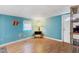 Bright bedroom featuring aqua walls, wood-look flooring, and a comfortable interior at 717 W Coach N Four Dr, Leesburg, FL 34748