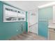 Cozy entryway with aqua walls, wood-look flooring, and a white door at 717 W Coach N Four Dr, Leesburg, FL 34748