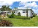 Single-story home featuring a well-manicured lawn and a covered carport at 717 W Coach N Four Dr, Leesburg, FL 34748