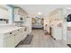 Well-lit kitchen with white appliances, adjacent dining area, and plenty of counter space at 717 W Coach N Four Dr, Leesburg, FL 34748