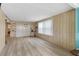 Open living room with wood flooring, natural light and a large window at 717 W Coach N Four Dr, Leesburg, FL 34748