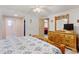 Comfortable bedroom featuring a light wood dresser, ceiling fan, and open access to the walk-in closet at 717 W Coach N Four Dr, Leesburg, FL 34748