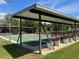 Covered shuffleboard courts featuring benches, offering a shady spot to play in a beautiful park at 717 W Coach N Four Dr, Leesburg, FL 34748