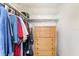 Walk-in closet with hanging clothes and multiple storage shelves with a chest of drawers at 717 W Coach N Four Dr, Leesburg, FL 34748