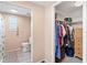 Bathroom and walk-in closet area with a fully stocked closet, and access to a well-lit bathroom at 717 W Coach N Four Dr, Leesburg, FL 34748