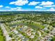 Aerial view of the home showcasing its location on a pond with mature trees in a vibrant neighborhood at 804 Santa Rita Way, Lady Lake, FL 32159